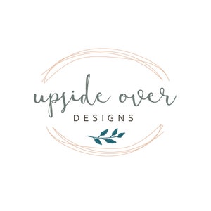 May include: A logo design featuring the text "upside over DESIGNS" in a handwritten style, enclosed within a double-lined oval. The text is in a muted teal color, with a sprig of teal leaves at the bottom. The oval is in a light brown color, all set against a white background.