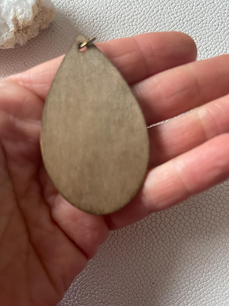 back of A pair of teardrop-shaped earrings lightweight wood earrings with a geometric block design. The earrings are made of thin wood and have a black, walnut stain and rose gold finish sections.