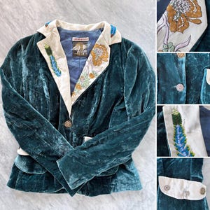 Op de afbeelding: Teal fluwelen blazer met crèmekleurige revers en manchetten. De revers zijn versierd met bloemen- en veervormige borduursels in goud, groen en blauw. De blazer heeft een enkele knoopsluiting en twee voorzakken.