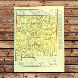 May include: Vintage map of New Mexico with a yellow and tan color scheme. The map features detailed geographical information, including roads, cities, and county lines. The map is printed on aged paper and has a classic aesthetic.