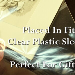 May include: A framed print is placed in a clear plastic sleeve. The text on the sleeve reads "Placed In Fitted Clear Plastic Sleeve! Perfect For Gifting!"