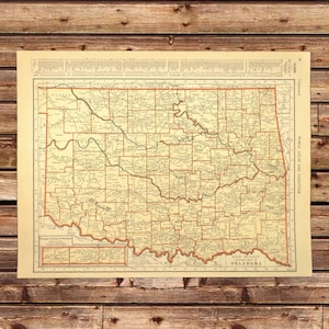May include: Vintage map of Oklahoma, showing county boundaries and major rivers. The map is printed on cream-colored paper with brown and red lines. The title "World Atlas and Gazetteer" is printed in the upper right corner.