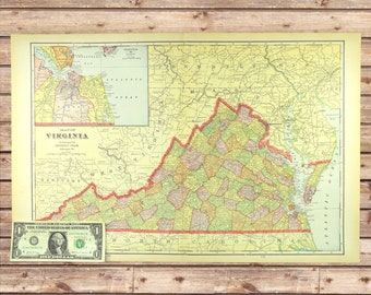May include: A vintage map of Virginia, featuring detailed county lines and geographical features. The map is printed on aged paper with a yellowed border. A one-dollar bill is placed near the map for scale, showing the map's size.