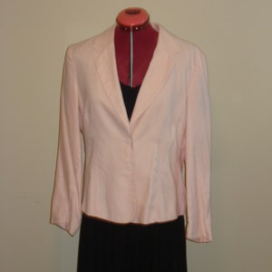 May include: A pale pink blazer with a single button closure. The blazer is on a dress form and has long sleeves.