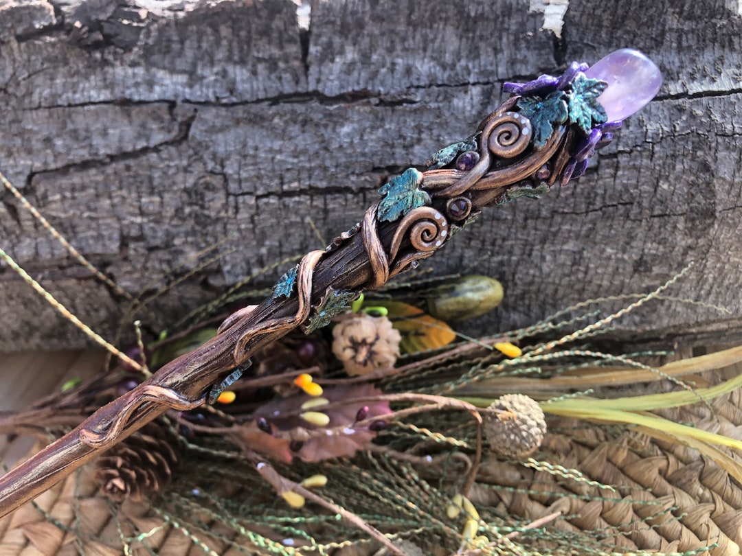 Handcrafted amethyst crystal witch wand resting on natural wood and dried botanicals – real witch wand example