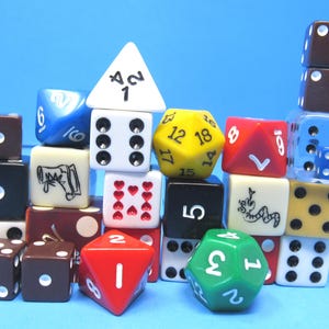 May include: A collection of colorful dice in various shapes and sizes, including six-sided, eight-sided, and twelve-sided dice. The dice are in shades of red, green, yellow, blue, white, and brown, with white pips and numbers. The dice are stacked against a blue background.