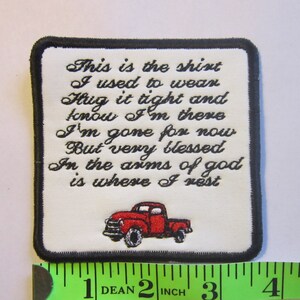 Peut inclure: Patch brodé blanc avec du texte noir et un camion rouge. Le texte dit : "This is the shirt I used to wear Hug it tight and know I'm there I'm gone for now But very blessed In the arms of god is where I rest"
