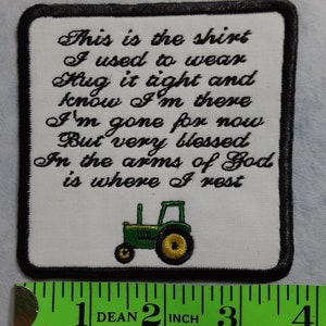 May include: White fabric patch with black border, featuring a green tractor and embroidered text: "This is the shirt I used to wear Hug it tight and know I'm there I'm gone for now But very blessed In the arms of God is where I rest".