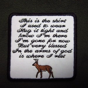 May include: White embroidered patch with black text that reads "This is the shirt I used to wear Hug it tight and know I'm there I'm gone for now But very blessed In the arms of god is where I rest". A brown deer is embroidered at the bottom of the patch.