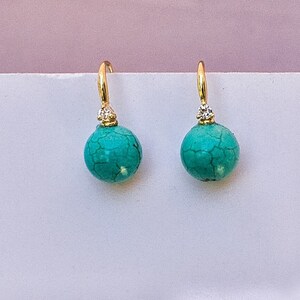 May include: A pair of gold earrings with turquoise stones and small diamond accents.