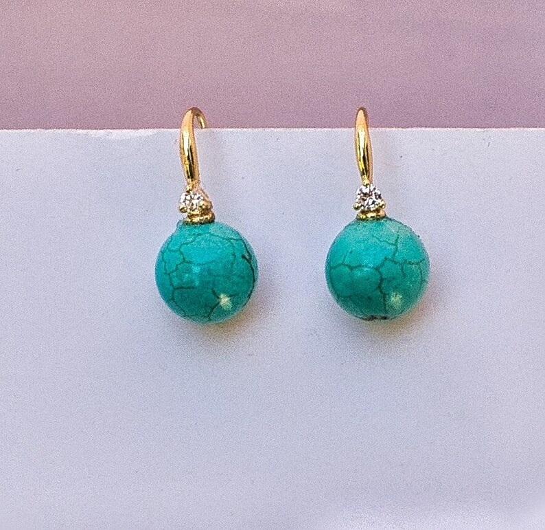 May include: A pair of gold earrings with turquoise stones and small diamond accents.