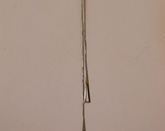 Minimalist box chain lariat style necklace in stainless steel with triangle charms and ball link and lobster claw clasp.