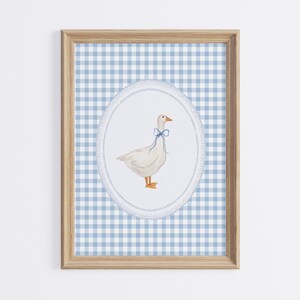May include: A framed print of a white goose with a blue bow tie on a blue and white gingham background.