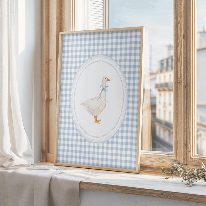 May include: A framed print of a white goose with a blue bow on a blue and white gingham background.