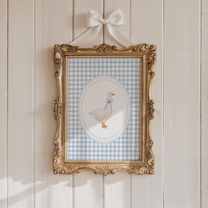 May include: A framed print of a white goose with a blue bow on a blue and white gingham background.