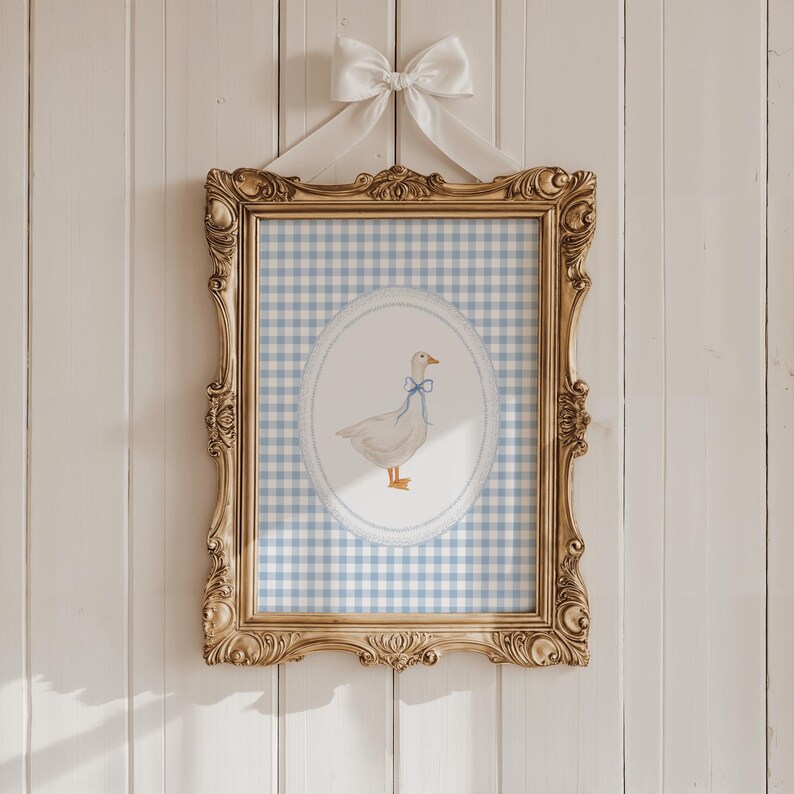 May include: A framed print of a white goose with a blue bow on a blue and white gingham background.