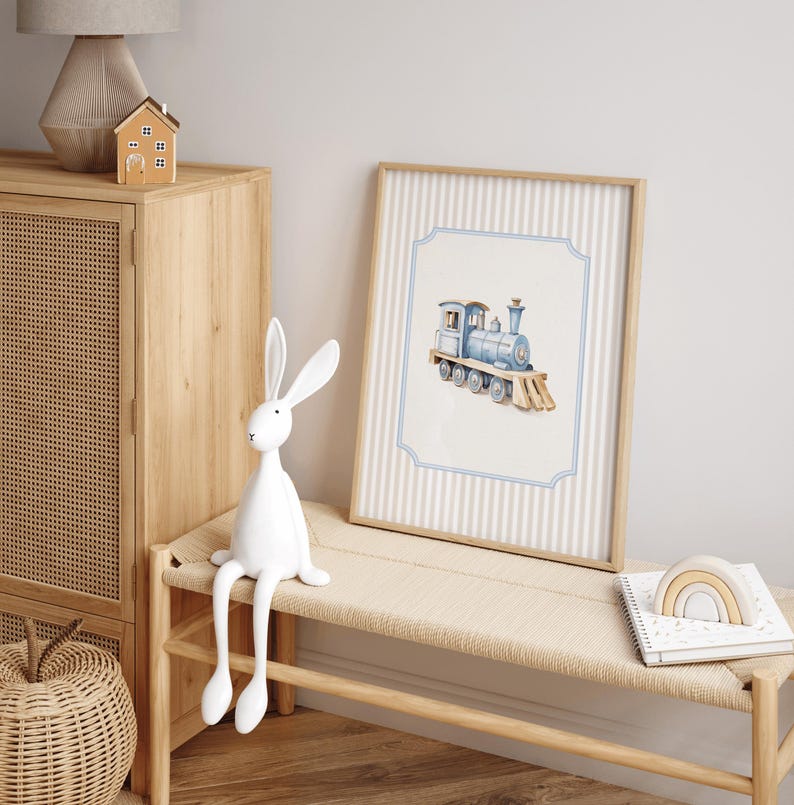 May include: A blue and white watercolor illustration of a toy train on a light blue background with a white border. The train is on a white and blue striped background with a wooden frame.