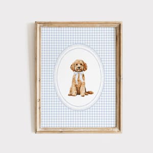 Könnte beinhalten: Ein gerahmter Druck mit einer Aquarellillustration eines Pudels. Der Hund ist hellbraun mit einer weißen Schleife, vor einem blau-weiß karierten Hintergrund in einem ovalen Rahmen. Der Holzrahmen verleiht einen klassischen Touch.
