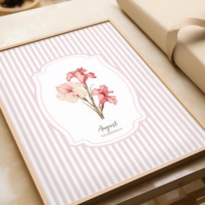 May include: A pink and white striped background with a white oval frame. Inside the frame is a watercolor illustration of pink and white gladiolus flowers. The text "August Gladiolus" is written below the flowers.