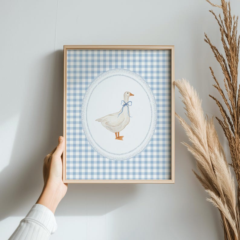 May include: A framed print of a white goose with a blue bow tie on a blue and white gingham background.