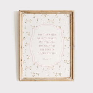 May include: Framed print with a floral pattern background and a pink oval frame containing text. The text reads "FOR THIS CHILD WE HAVE PRAYED, AND THE LORD HAS GRANTED THE DESIRES OF OUR HEARTS." The frame is a light brown color.