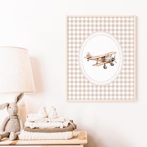 Pu&ograve; includere: Una stampa incorniciata con un'illustrazione di un biplano vintage. L'opera d'arte &egrave; ambientata su uno sfondo a quadretti beige e bianco, incorniciata in legno chiaro. L'aereo &egrave; nei toni del marrone e dell'argento, ideale per l'arredamento della cameretta.