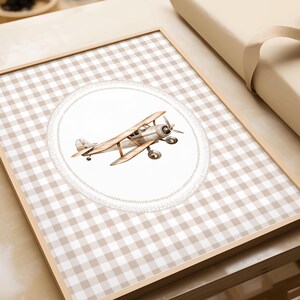Pu&ograve; includere: Una stampa incorniciata con un'illustrazione ad acquerello di un biplano vintage. L'aereo &egrave; in tonalit&agrave; marroni e grigie, su uno sfondo bianco con un bordo decorativo. Lo sfondo &egrave; un motivo a scacchi beige e bianco.