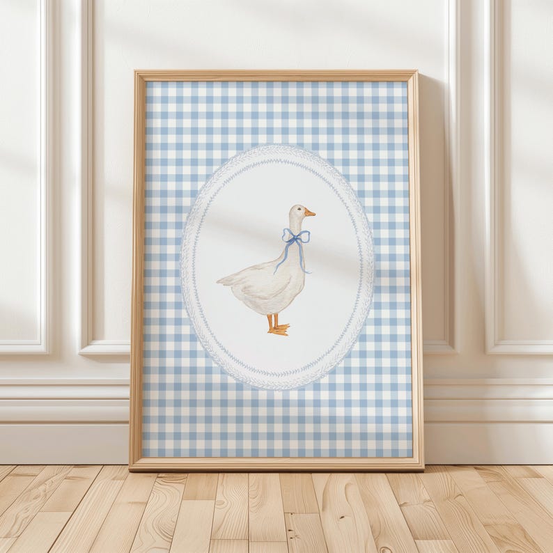 May include: A framed print of a white goose with a blue bow on a blue and white gingham background.