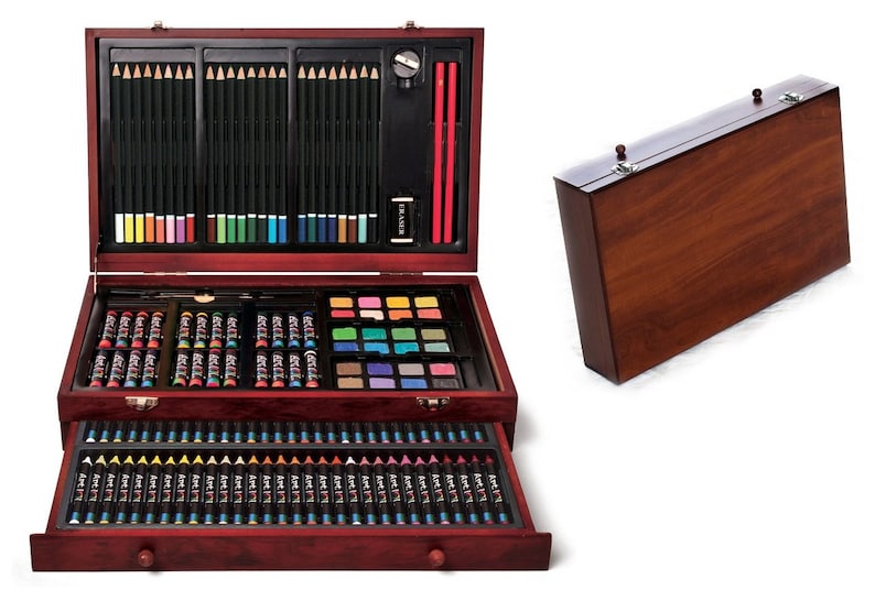 Peut inclure: Une bo&icirc;te en bois d'accessoires artistiques avec un tiroir, contenant des crayons de couleur, des crayons, des marqueurs et de la peinture. La bo&icirc;te est ouverte et le tiroir est tir&eacute; vers l'ext&eacute;rieur, r&eacute;v&eacute;lant le contenu.