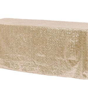 Könnte beinhalten: Eine goldene Sequin-Tischdecke. Die Tischdecke ist aus einem weichen, schimmernden Stoff gefertigt und perfekt, um jeder Veranstaltung einen Hauch von Glamour zu verleihen.