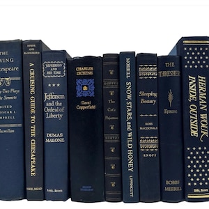 Könnte beinhalten: Eine Sammlung von 12 antiken gebundenen Büchern mit dunkelblauen Einbänden und goldenen Schriftzügen. Die Titel lauten "The Living Shakespeare", "A Cruising Guide to the Chesapeake", "Jefferson and His Time", "David Copperfield", "The Cat's Pajamas", "Snow, Stars, and Wild Honey", "Sleeping Beauty", "The Thresher", "Inside, Outside" und "Herman Wouk".