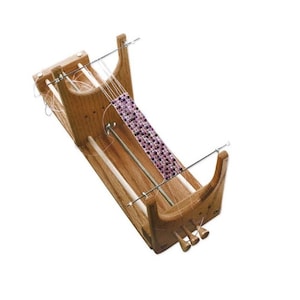 May include: Wooden bead loom with a purple beaded bracelet being made on it.