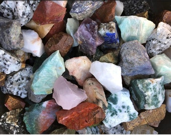 Puede incluir: Una colección de piedras preciosas sin pulir en bruto en varios colores, incluidos verde, azul, morado, rosa, blanco y marrón. Las piedras son de diferentes tamaños y formas, y algunas tienen una textura natural y rugosa.