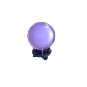 May include: A translucent, lavender-colored crystal ball sits atop a dark wooden stand. The sphere reflects light, creating highlights. The stand has a carved, ornate design. This item is often used for divination and fortune-telling.