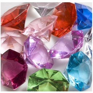 May include: A collection of colorful, faceted, plastic gems in various shapes and sizes. The gems are red, pink, purple, blue, green, and clear.