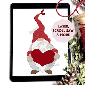 May include: A digital illustration of a gnome holding a red heart. The gnome wears a red hat and has a long white beard. The text "LASER, SCROLL SAW & MORE" is in a pink bubble.