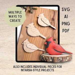 May include: Three light-coloured wooden cardinal bird cutouts with engraved wing details and one finished, painted red cardinal figurine with a black face mask, displayed on a wood slice. Text includes MULTIPLE WAYS TO CREATE, SVG, AI, PNG, PDF, and ALSO INCLUDES INDIVIDUAL PIECES FOR INTARSIA-STYLE PROJECTS.