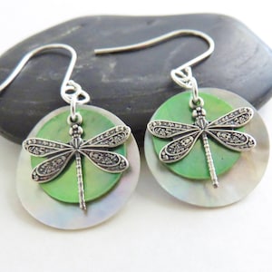 May include: A pair of silver dragonfly earrings with green and white iridescent shell accents.