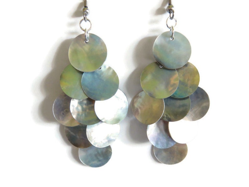 A close up of iridescent mussel shell earrings on a white background.