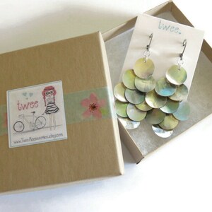 Mussel shell earrings on a display card inside a square kraft paper jewelry gift box. The box is decorated with floral washi tape and a sticker with the twee logo.