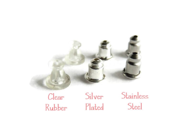 May include: An assortment of earring backs in clear rubber, silver plated, and stainless steel. The text in the image reads "Clear Rubber", "Silver Plated", and "Stainless Steel". The earring backs are displayed on a white background.