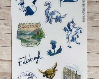 Può includere: Un foglio di adesivi con varie illustrazioni tra cui la bandiera scozzese, il mostro di Loch Ness, un unicorno, un cardo, una mucca delle Highlands, un paesaggio di Loch Ness, una scena di strada e il testo Edinburgh e Scotland Loch Ness.