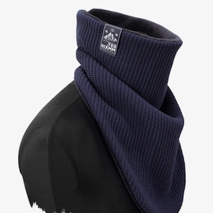Könnte beinhalten: Ein dunkelblauer Strick-Halswärmer mit Fleece-Futter. Der Halswärmer hat ein kleines Logo mit dem Text "The Six Mountain" darauf.