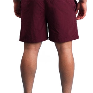 Puede incluir: Un pantal&oacute;n corto de color burdeos con un bolsillo con cremallera en la parte posterior. El pantal&oacute;n corto est&aacute; hecho de una tela ligera y resistente al agua.