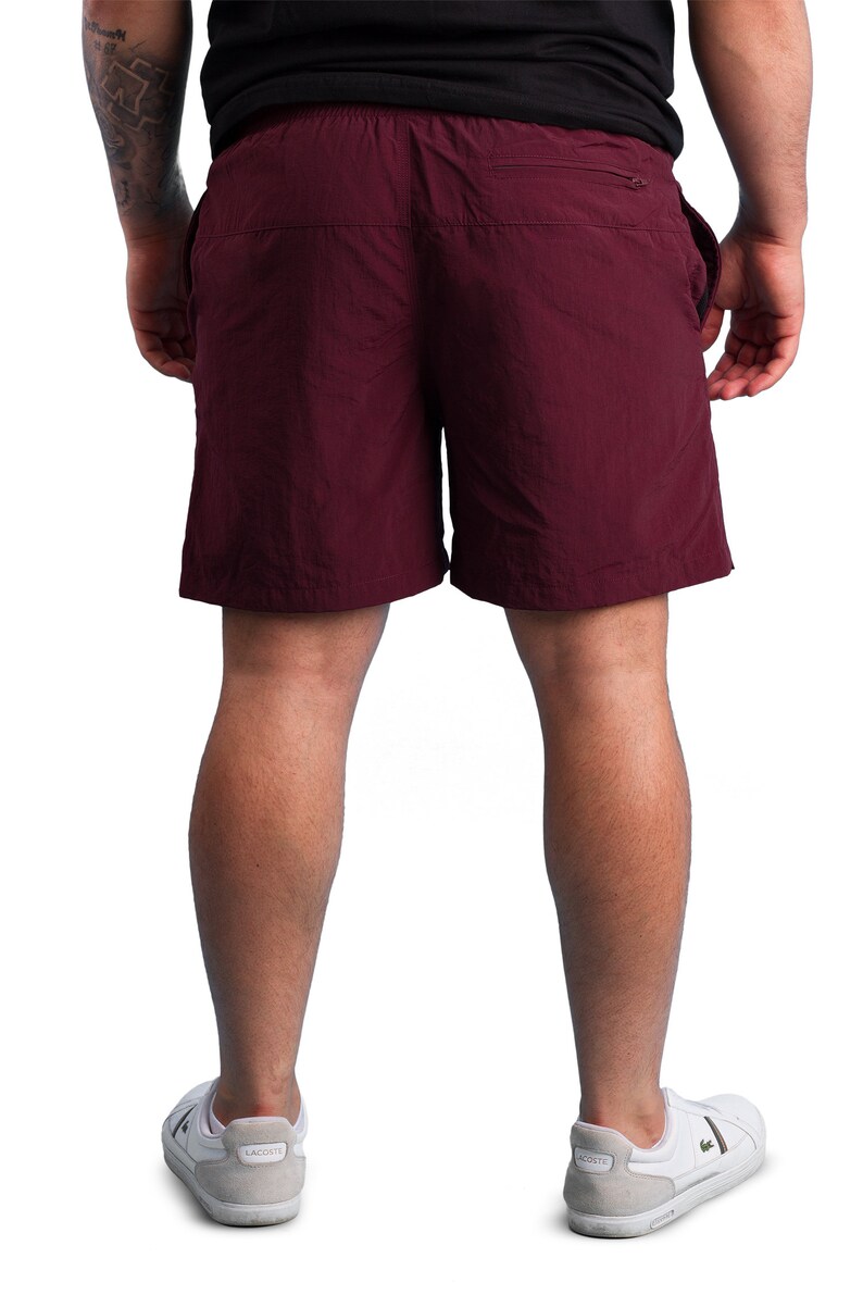 Puede incluir: Un pantal&oacute;n corto de color burdeos con un bolsillo con cremallera en la parte posterior. El pantal&oacute;n corto est&aacute; hecho de una tela ligera y resistente al agua.