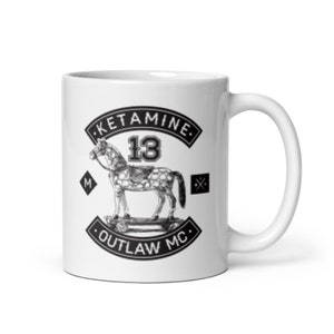 Può includere: Tazza in ceramica bianca con una grafica in bianco e nero di un cavallo su uno skateboard. La grafica include il testo "Ketamine 13 Outlaw MC".