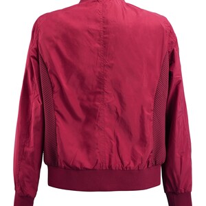 May include: A burgundy bomber jacket with a ribbed collar, cuffs, and hem. The jacket has a smooth, shiny finish and a subtle mesh panel on the sides.