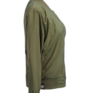 May include: A green bomber jacket with a zipper closure and a small logo on the bottom left side.