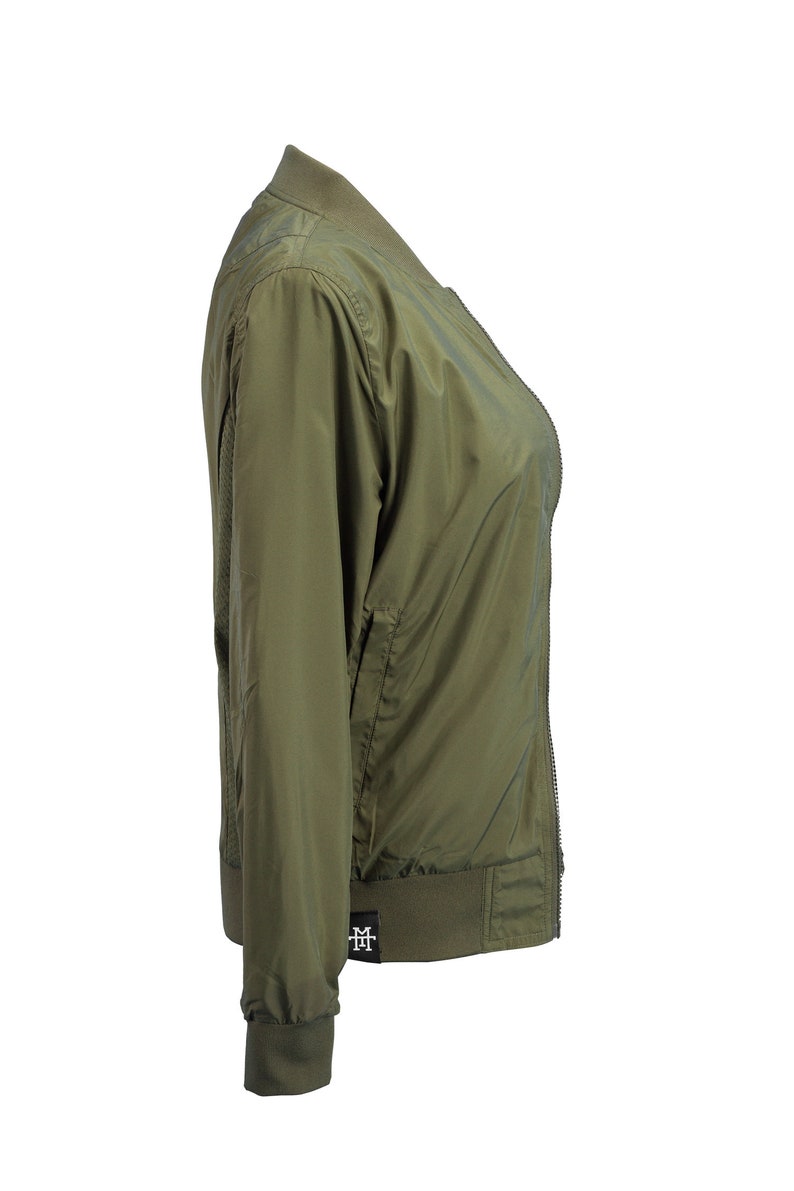 May include: A green bomber jacket with a zipper closure and a small logo on the bottom left side.