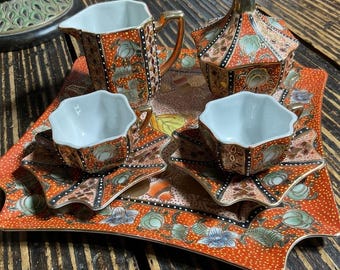 Servizio da tè giapponese in porcellana con decorazioni floreali arancioni e dorate per il fine settimana.